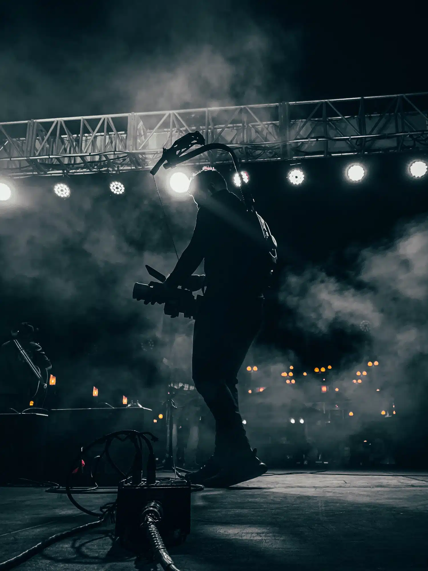 a videographer onstage at a concert filming a band